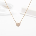 Macro di una collana con pendente a cuore dorato con zirconi brillanti incastonati - Stile Cuore Pieno / Oro