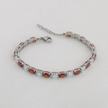 Detail van zilveren tennisarmband met oranje en witte ovale zirkonia edelstenen - Zilver + Witte & Rode Steen