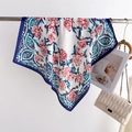 Detail of silk scarf with red floral pattern and navy border hanging on a metal rack - Navy Border (White Peony)