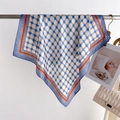 Detailed close-up of geometric silk scarf with blue chain patterns and orange borders - Blue