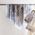 Dettaglio di un foulard in seta quadrato con bordi blu e stampe architettoniche su gruccia - 70cm / Blu