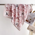 Dettaglio di un elegante foulard in seta a fiori appeso vicino a una borsa trapuntata - Cachi