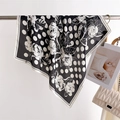 Polka dot and floral silk scarf shown hanging next to an elegant white quilted bag - Black (FJ997-2)
