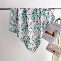 Detail of floral printed silk scarf in mint green and pink hung on a metal rack - 70x70cm / Green (FJ988-2)