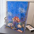 Macro detail of blue silk scarf featuring elegant lotus floral prints and fine fabric texture - Blue