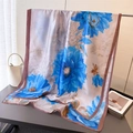 Macro detail of silk scarf featuring large blue floral prints and brown rolled edges - Blue (Beige with Blue Flower Pattern)