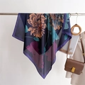 Detail of floral silk-feel scarf with blue base and orange flowers on a metal rack - Navy Contrast Flowers (FM306-2)
