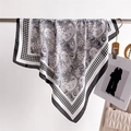 Detail eines eleganten Seidenschals mit Hahnentrittmuster und Paisley-Print am Ständer - Schwarz (FJ960-2)
