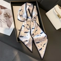 Detail of elegant whale print silk scarf tied in a bow next to a white handbag - Ocean Whale Hand-Drawn Style (LE24-3) / White Whale