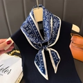 Blue and white paisley silk scarf displayed on a wooden hanger with a classic geometric border - 147x14cm / Navy Blue