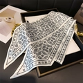 Close-up of black and white paisley skinny scarf in elegant tray for versatile styling - 147x14cm / White
