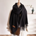 Solid black tassel scarf with brand leather label on a mannequin for autumn winter - Black