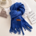 Detail of soft blue scarf texture with fringe tassels and a sewn brown leather label - Sapphire Blue
