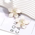 Exaggerated large white enamel flower stud earrings with elegant gold trim detail - White
