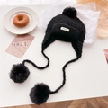 Detail of black knitted balaclava with soft pom-poms and sheep-like wool texture - Black