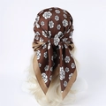 Detail of silk-like brown headscarf with white camellia print on model head - 90x90cm / Coffee Camellia Style (FN251-3)