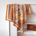 Dettaglio di un foulard di seta con motivo paisley drappeggiato su un supporto - 90x90cm / Arancione