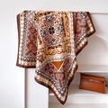 Dettaglio di un foulard di seta paisley drappeggiato su un supporto minimalista - 90x90cm / caffè