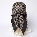 Close-up of geometric V-pattern silk scarf tied on a blonde mannequin head in black and gold - 90x90cm / Beige-Black