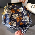 Detailed view of square silk scarf with blue houndstooth edge and orange floral print - 70x70cm / Navy Blue