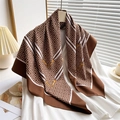 Brown and white geometric print silk scarf hanging on a white shirt with warm lighting - Brown