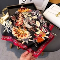 Dettaglio di un foulard quadrato in seta con fiori arancioni e bordo rosso vivo - Nero