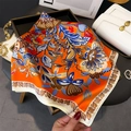 Dettaglio di un foulard setoso con motivo floreale retrò e finitura satinata lucida - Arancione