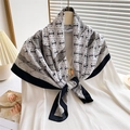 Detail of elegant silk scarf with geometric pattern and black border on shirt - White