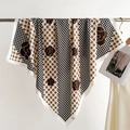 Elegant 90cm square silk scarf with camellia and houndstooth pattern hanging on a rack - White Edge Pink