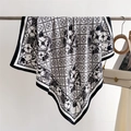 Dettaglio di un foulard in seta monocromatico con motivi floreali e geometrici su supporto - Bianco / 90cmx90cm