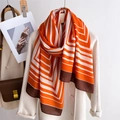 Sciarpa lunga chic a righe geometriche arancioni e bianche su cappotto di lana beige - Arancione