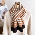 Elegant striped long scarf in coffee and black cotton linen draped on a white coat - Khaki