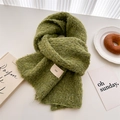 Detail of green wool scarf with boucle texture and ins label on white table setup - Grass Green