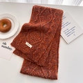Close-up of caramel orange cable knit wool scarf with colorful flecks and brand label - 160x22cm / Orange Red