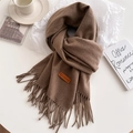 Deep brown winter scarf with tassels and leather logo patch on a cozy white backdrop - Mottled Coffee