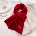 Close-up of red knitted scarf with colorful dachshund embroidery on beige suit fabric - 164x20cm / Red