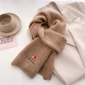 Close-up of camel knit scarf with detailed dachshund embroidery on a white blazer - 164x20cm / Khaki