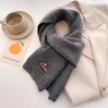Close-up of a grey knitted scarf featuring a small embroidered dachshund with balloons - 164x20cm / Dark Gray