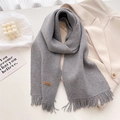 Detail of grey knitted scarf showing soft fringe and brown leather Handmade label - Gray