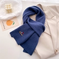 Close-up of navy blue knit scarf featuring a cute embroidered dachshund dog pattern - 164x20cm / Blue