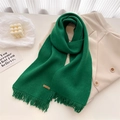 Detail of dark green knit scarf with tassels and Hand Made label on beige blazer - Emerald Green
