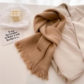 Detail of camel knitted scarf with Hand Made leather label and long fringe accents - Camel