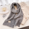 Detailed close-up of thick grey wool knit scarf featuring a signature brand logo label - 161x21cm / Gray