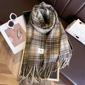 Close-up of soft plaid scarf with fringe detail and brand label on leather background - Green Brown (WT180-5)