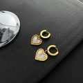 Elegant heart shell hoop earrings with golden hollow design on black background - Gold