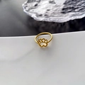 Golden titanium steel ring featuring a hollow cat paw design on a white display stand - Titanium Steel Cat Paw Ring (JZ-107) / Gold