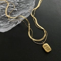 Collana a doppio strato dorata con catena a serpente e ciondolo quadrato su base nera - Collana a Doppio Strato Dorata con Piastrina a Lettere (01-D16)
