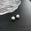 Pendientes minimalistas de plata s925 con perlas naturales blanco crema sobre un fondo negro - Grande (0.6cm) / Blanco