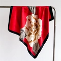 Dettaglio di un foulard in raso rosso con stampa di camelia bianca e bordo nero - Rosso