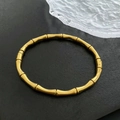 Minimalistisches Vintage-Gold-Bambusarmband aus Titanstahl für Damen auf schwarzem Grund - Gold